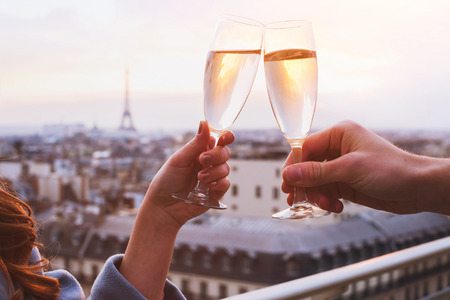 Cheers with two champagne glasses on a trip to Paris