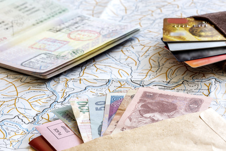 Passport, credit cards, and money layed out on a map