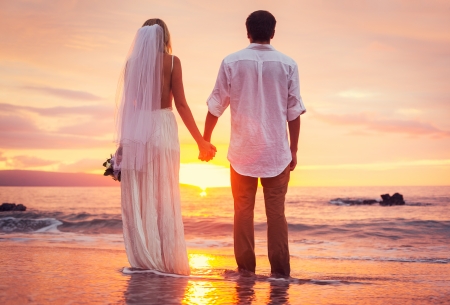 bride and groom, enjoying amazing sunset on a beautiful tropical beach, romantic married couple