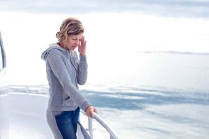 cruise sea motion sickness young tourist woman. seasick on boat vacation with headache. fear of travel or illness virus on cruising holiday