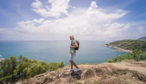 young traveler man at summer holiday vacation with beautiful mountains and seascapes at background