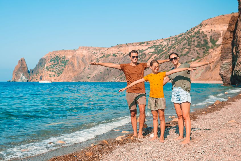 young family on white beach during summer vacation
